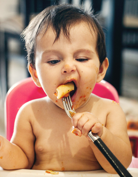 cute baby eating pasta with fork