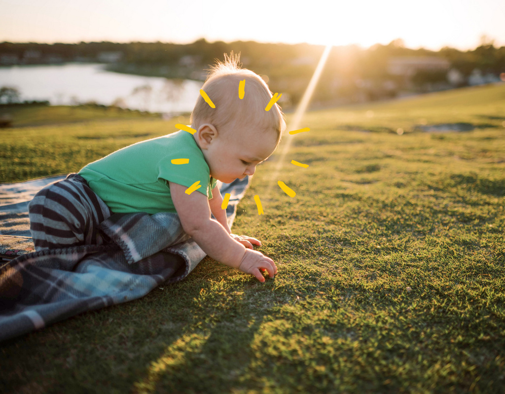 Baby playing i grass with sunshine