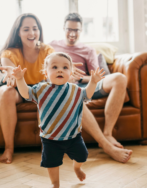 Padres felices viendo a su bebe caminar