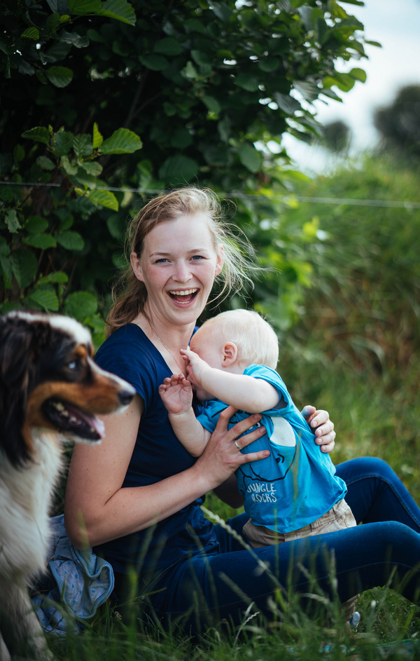 Mujer sonriente con bebe y perro